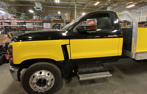 The truck is covered with a yellow vinyl wrap.